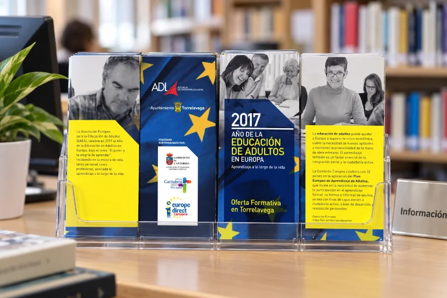 ADL Torrelavega · folleto de educación de adultos: expositor en la biblioteca